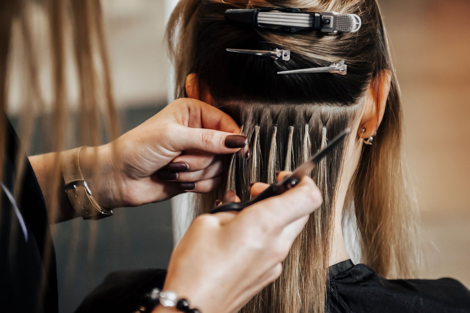 hairstylist installing i-tip hair extenions in salon
